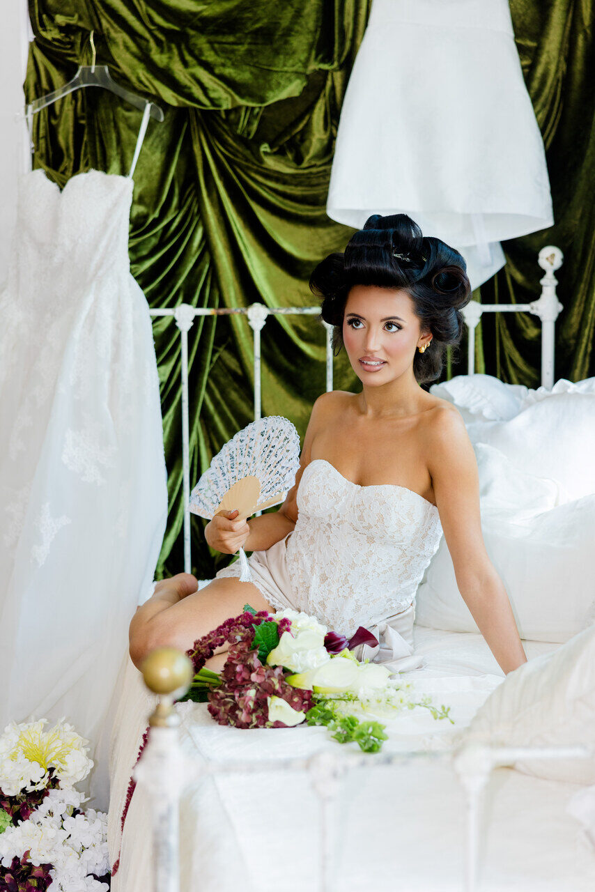 Bride holding a lace fan during bridal portraits