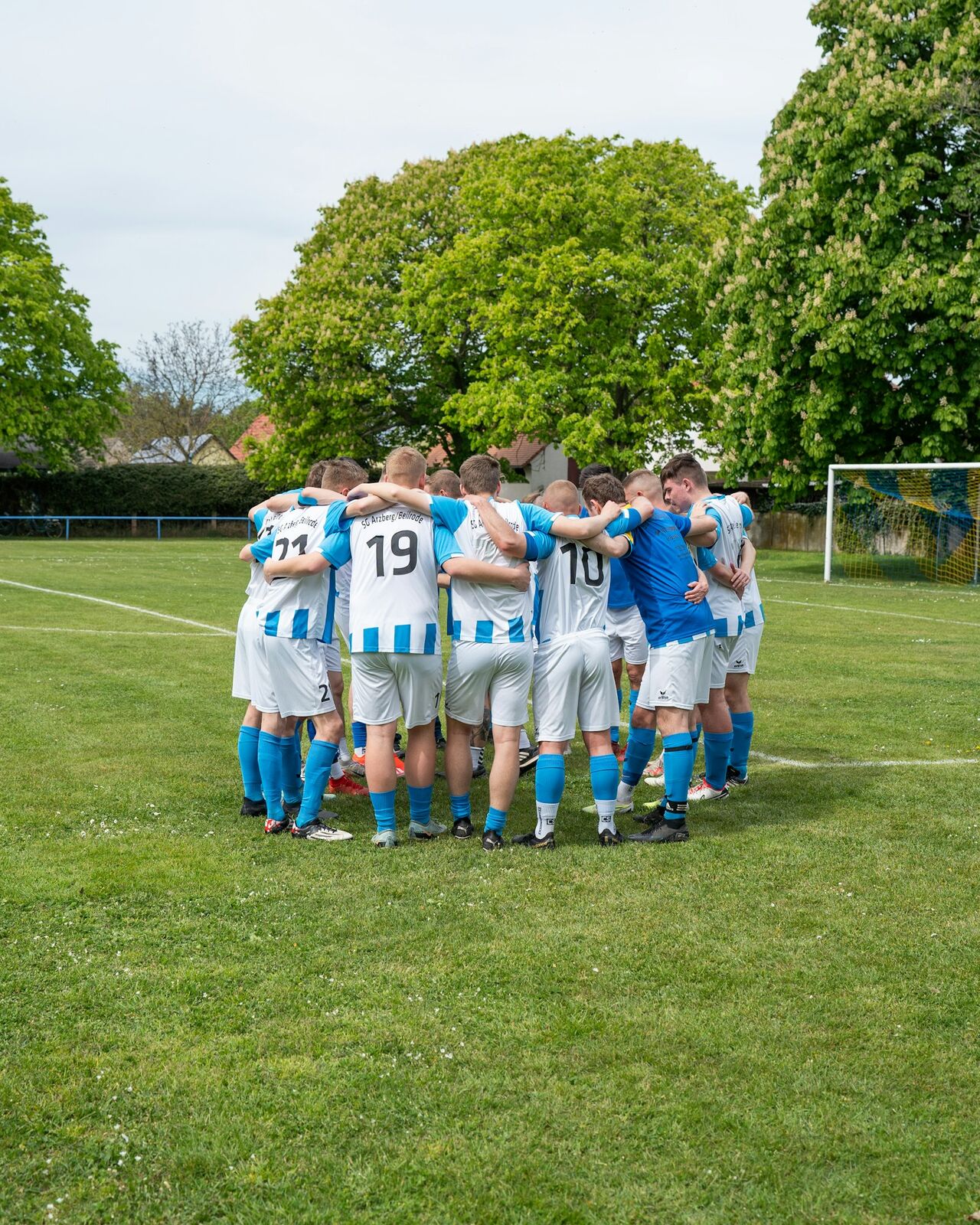 Youth soccer team in a huddle on the field